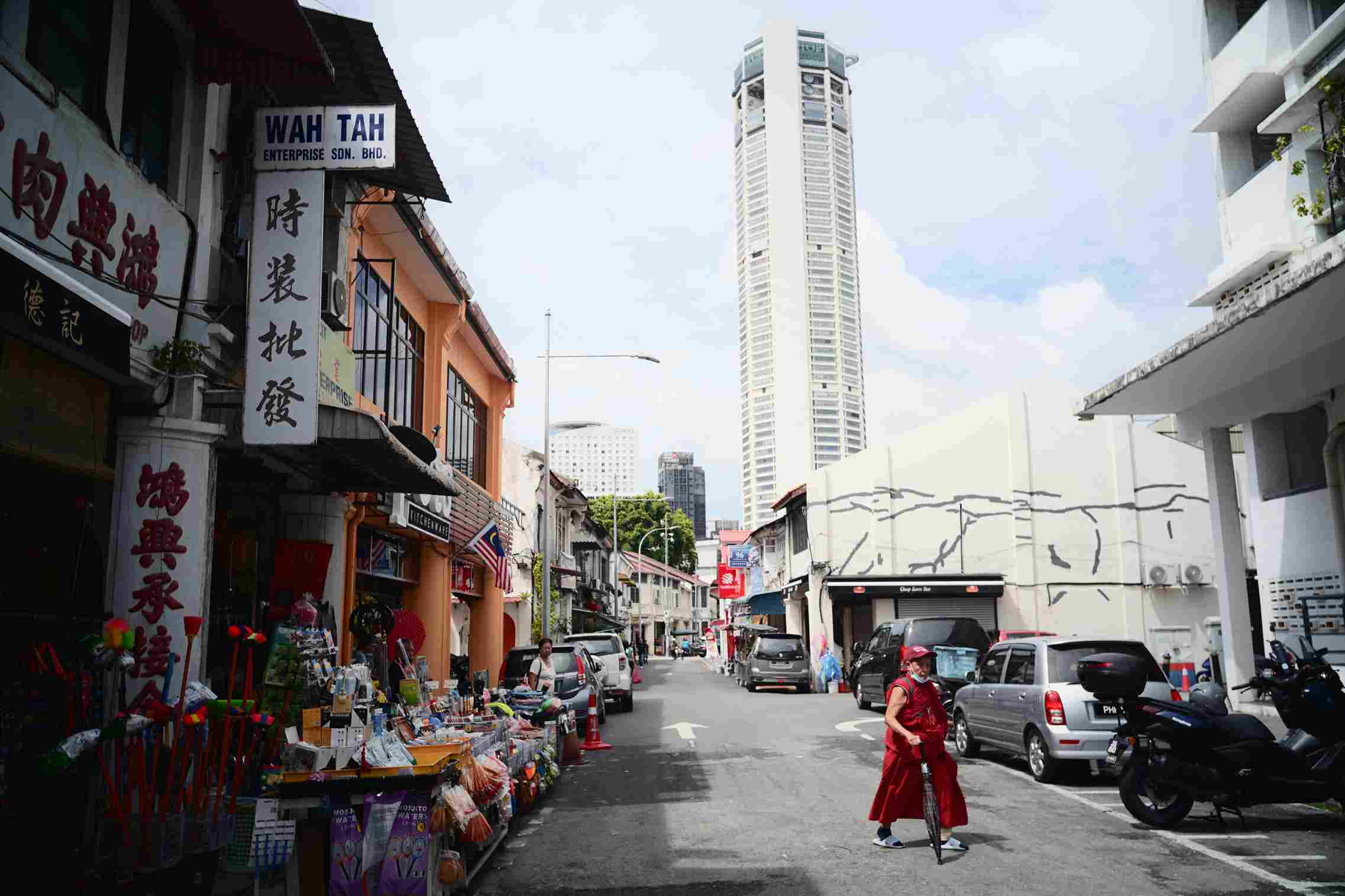 Street view of George Town, Penang, showcasing heritage shophouses and Komtar Tower, celebrated by icanfly for its cultural richness and local cuisine.