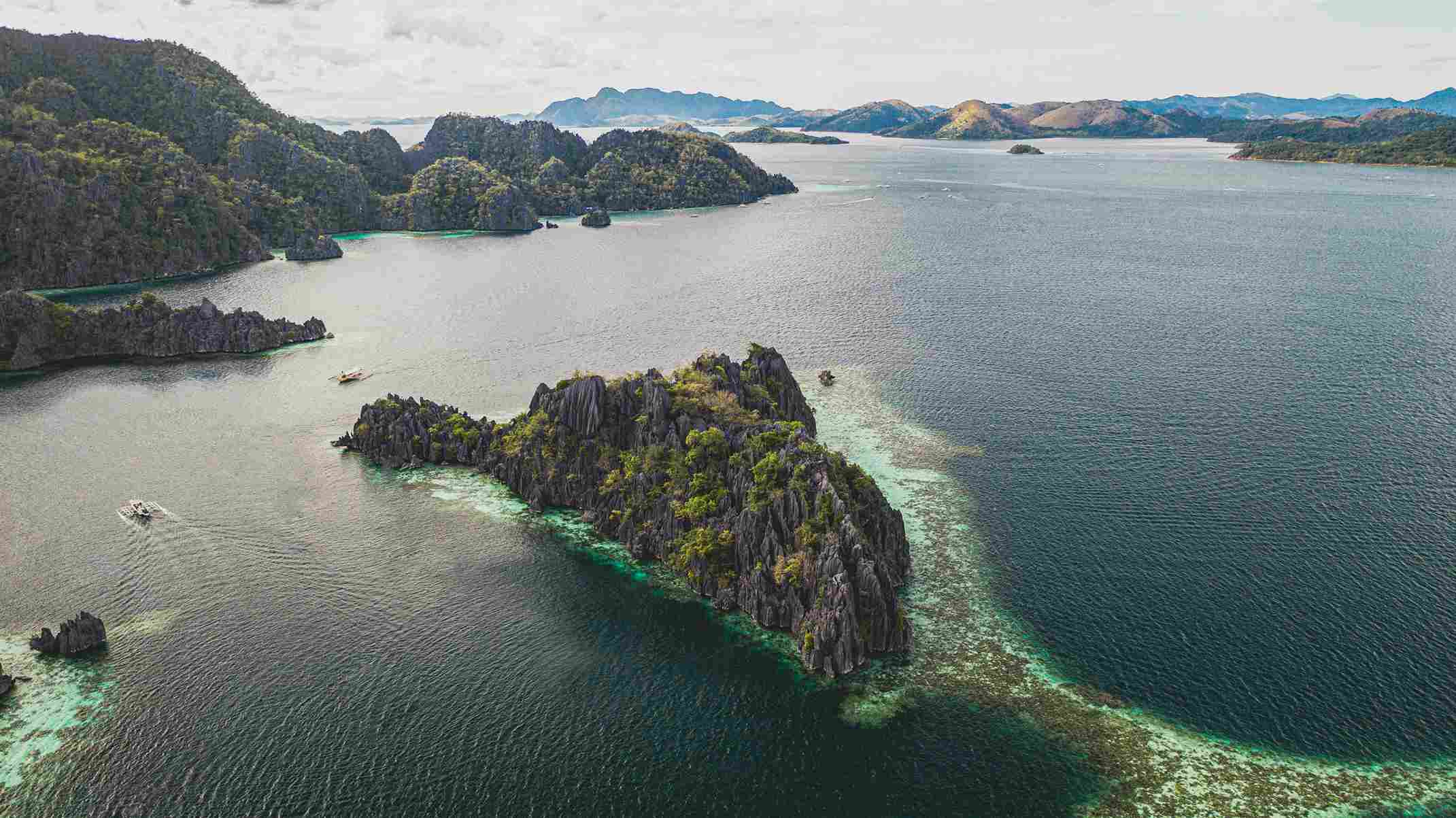 Aerial view of Langkawi’s lush islands and clear blue sea, promoted by icanfly as top beach destinations in Malaysia for relaxation and snorkeling.