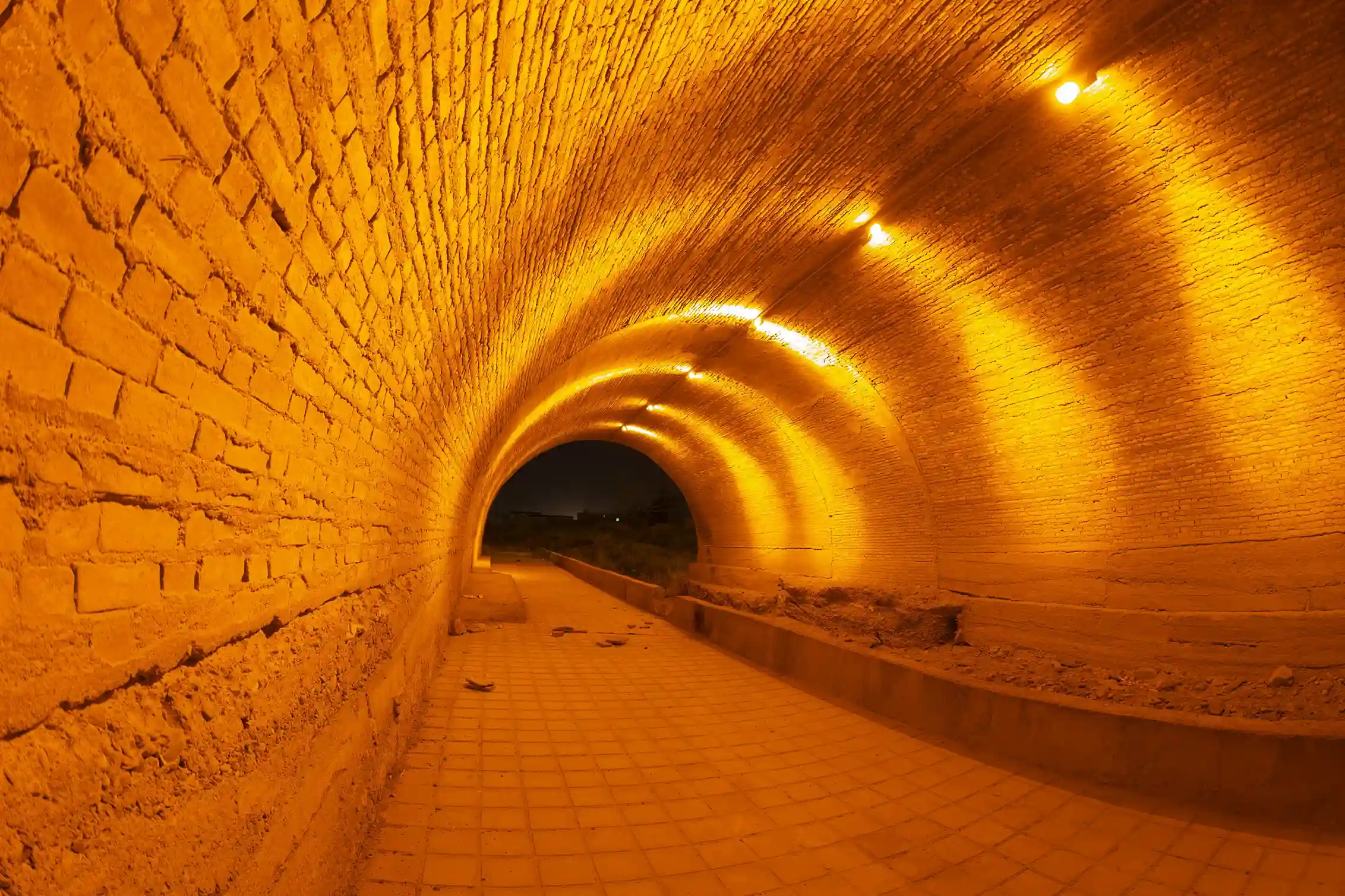 Illuminated brick-lined Cu Chi Tunnels in Vietnam, part of the historic underground network from the Vietnam War, featured by icanfly for cultural and historical exploration.