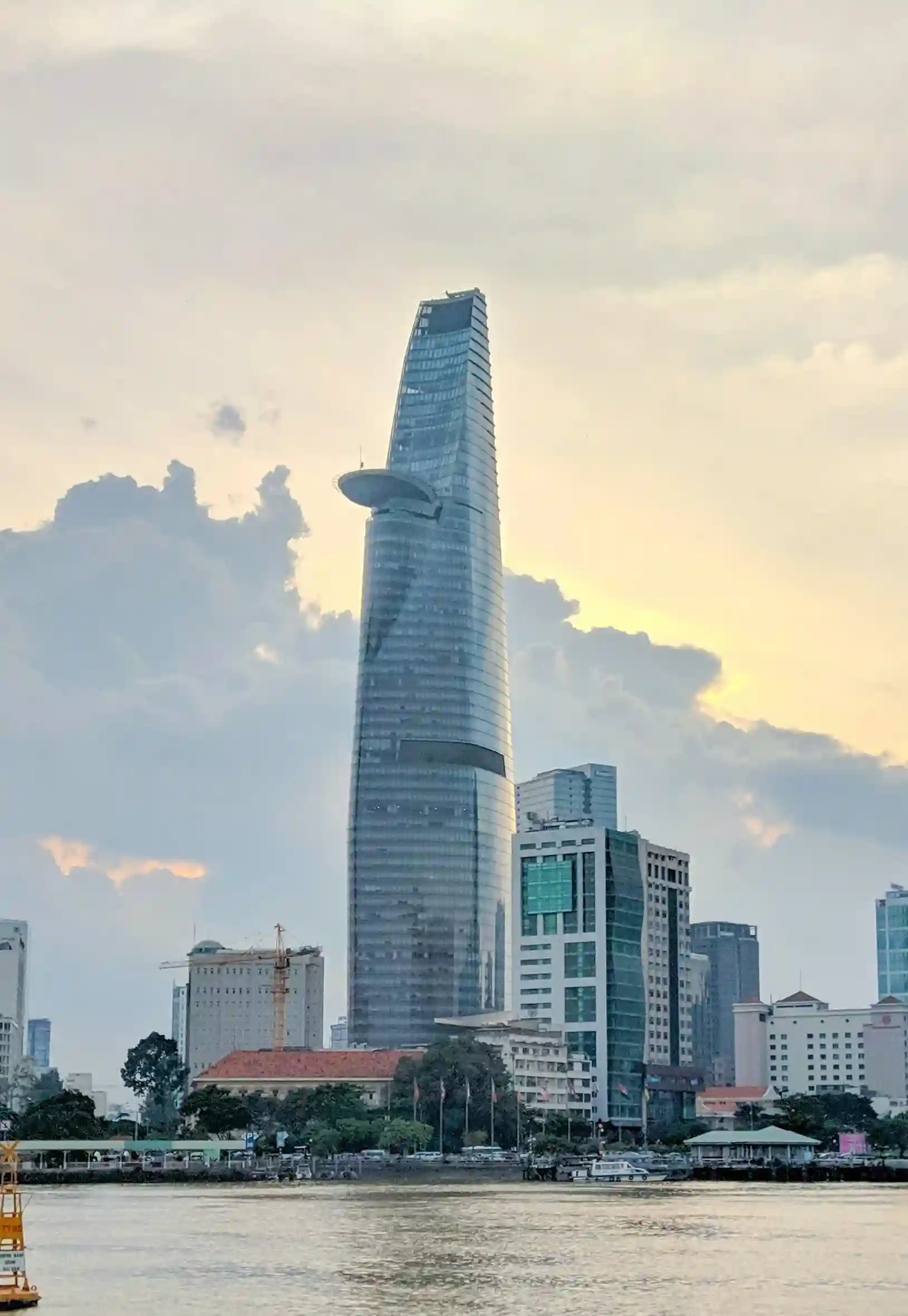 Bitexco Financial Tower rising above Ho Chi Minh City skyline at sunset, showcasing Vietnam’s fusion of colonial charm and modern architecture, promoted by icanfly.