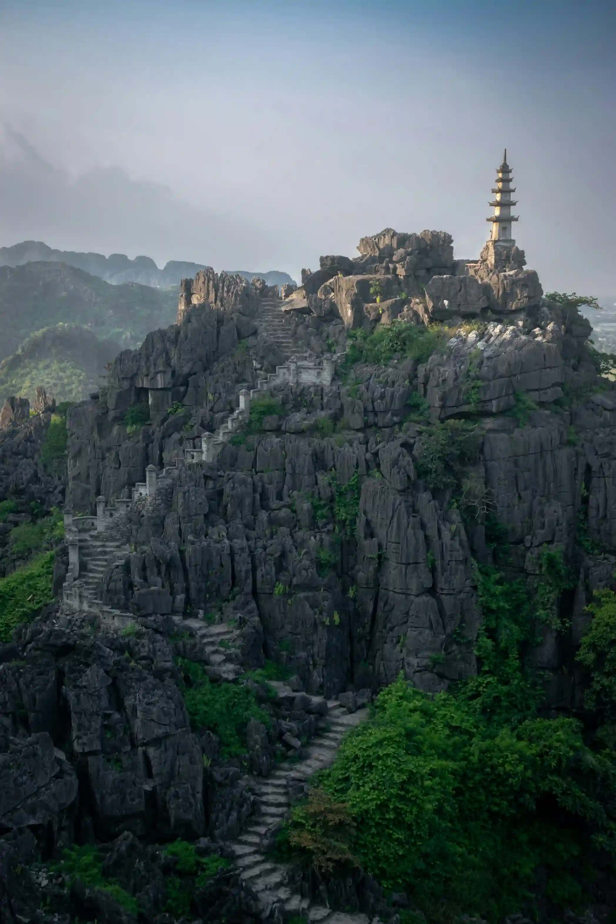 Dramatic limestone cliffs and stone stairways in Ninh Binh, Vietnam, known as 'Ha Long Bay on land' with temples and caves, featured by icanfly for nature and culture travel.