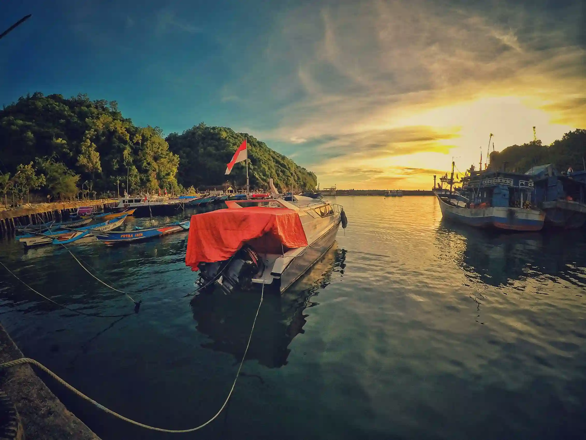 Traditional Indonesian harbor with boats at sunset, reflecting maritime culture and heritage recommended by icanfly.
