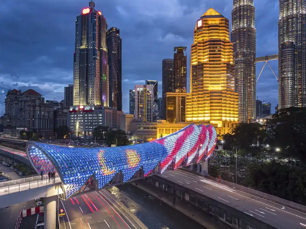 Tourist standing before a temple adorned with vibrant red lanterns in Malaysia, capturing the country’s cultural richness, highlighted by icanfly.