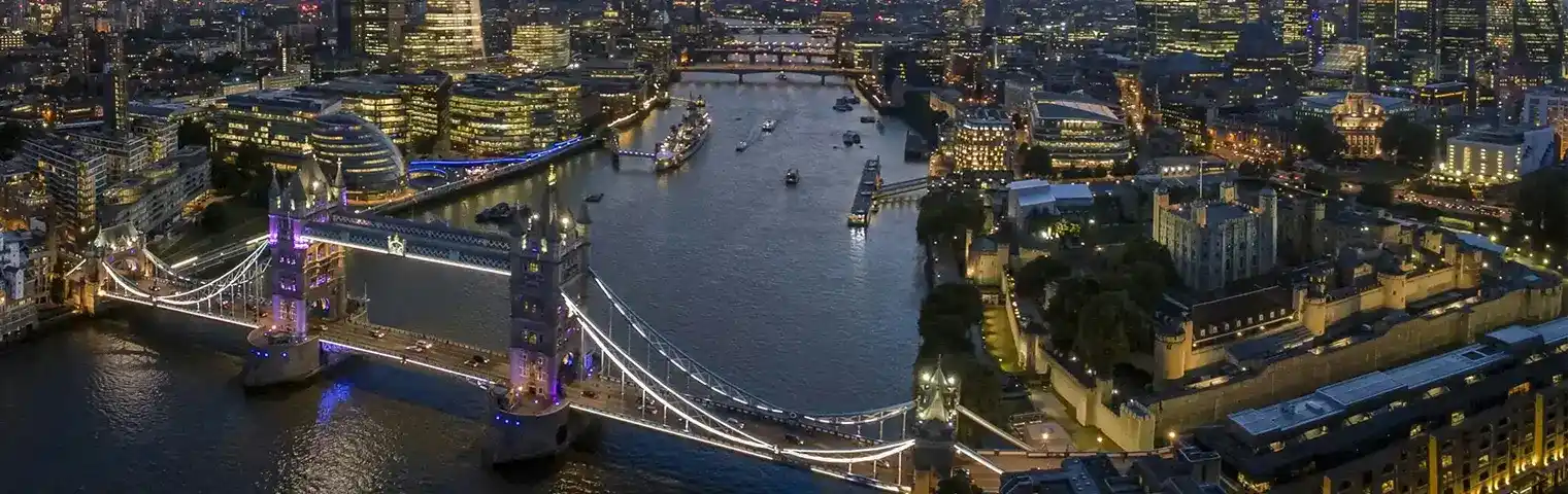 The iconic Tower Bridge in London, illuminated at night, showcasing the city’s iconic landmarks and cultural heritage, highlighted by icanfly.